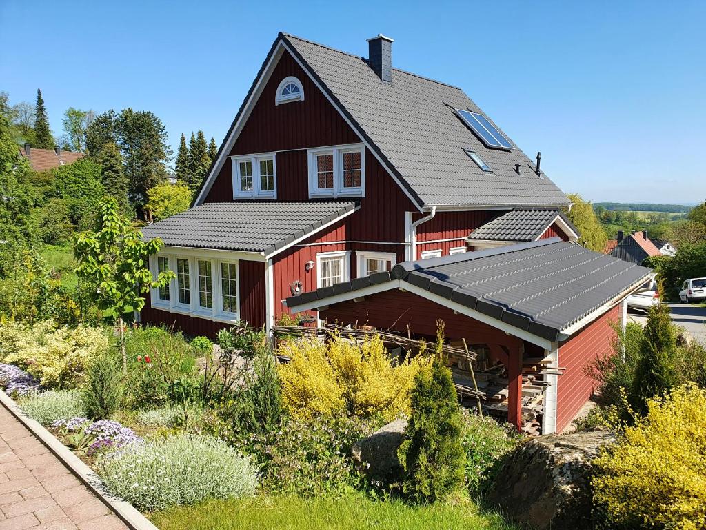 霍恩-巴特迈恩贝格Haus Nordlicht的一座大型红色房子,上面装有太阳能电池板