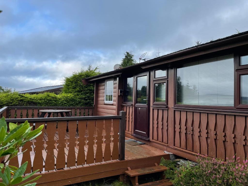特兹西尼德Cosy 2 bedroom Log Cabin in Snowdonia Cabin151的房屋设有木甲板和桌子