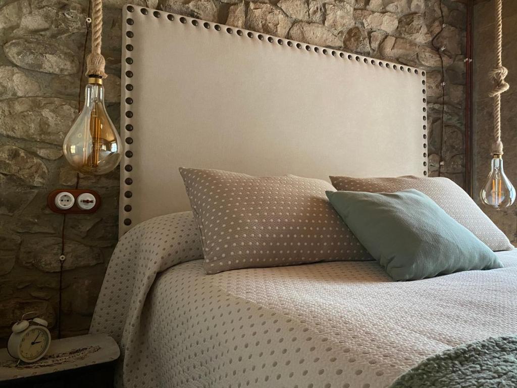 RíosecoEl Apartamentin - en el corazón del Parque Natural de Redes的卧室配有白色的床铺和石墙