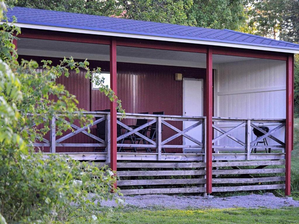 埃斯基尔斯蒂纳4 person holiday home in ESKILSTUNA的红色和白色的建筑,设有门廊和楼梯