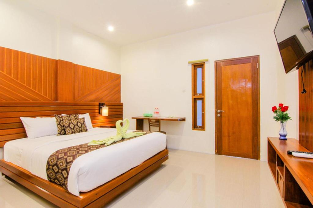日惹S5 Guest House Yogyakarta的一间卧室配有一张大床和电视