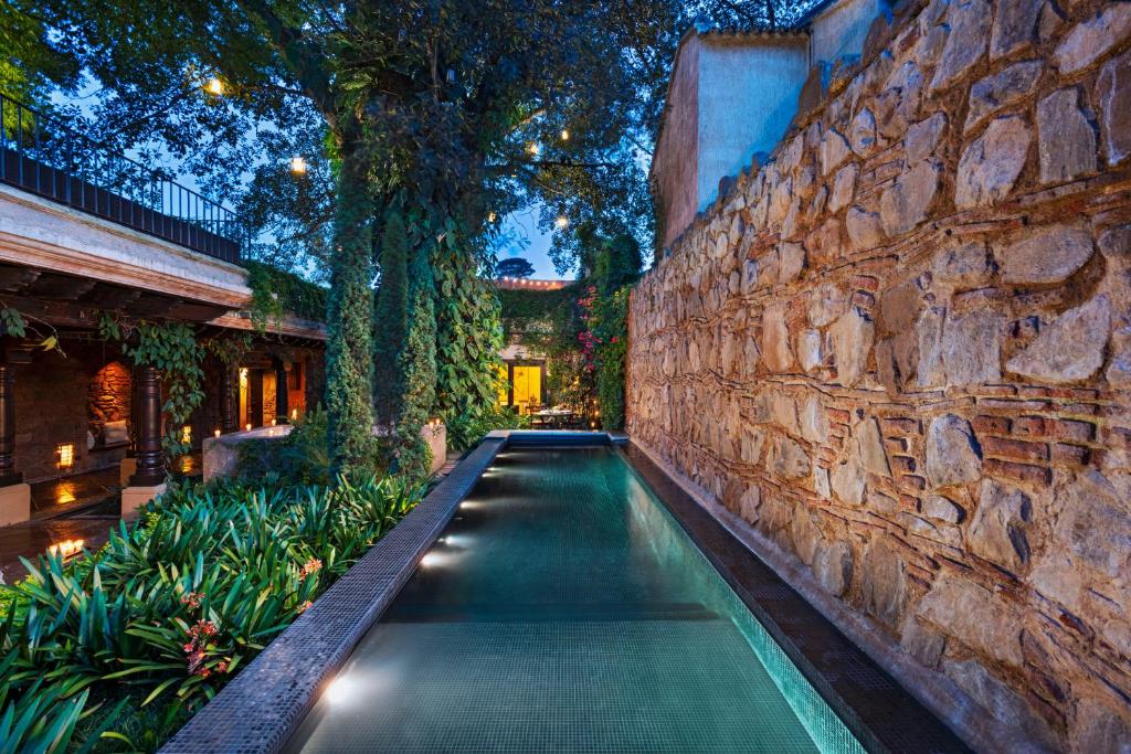 危地马拉安地瓜埃尔孔本托精品酒店的石头墙前的游泳池