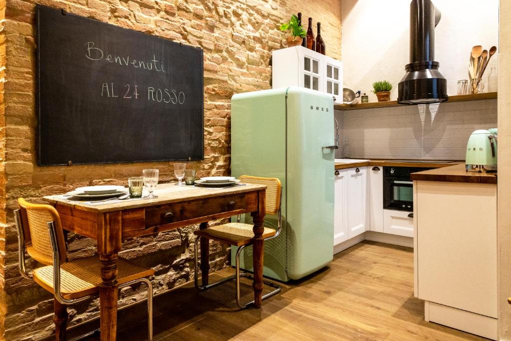 锡耶纳Al 24 Rosso的厨房配有桌子和绿色冰箱。
