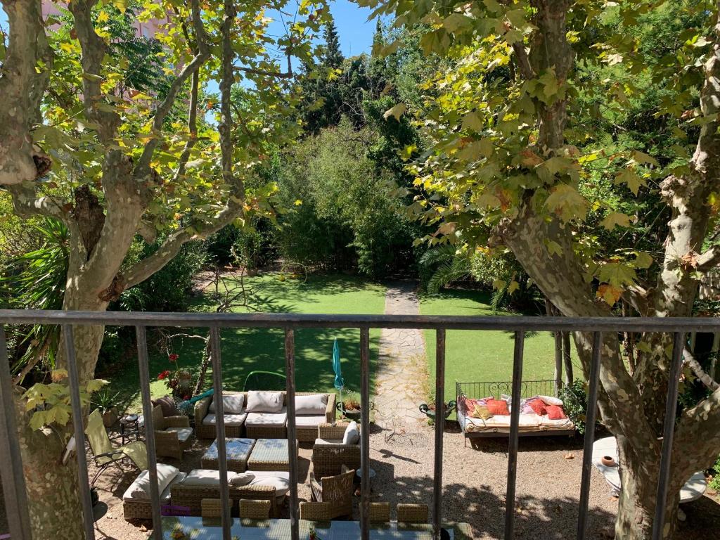 马赛Le Transvaal-Maison d'Hôtes的享有带椅子和一棵树的花园美景。
