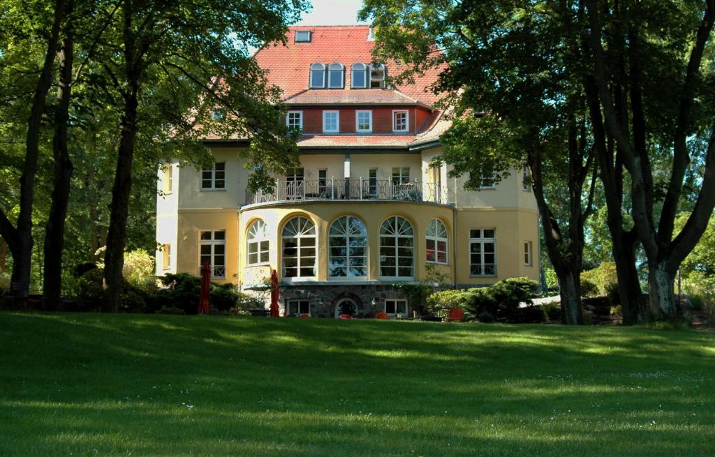 菲尔斯滕贝格Landhaus Himmelpfort am See的大房子,大院子,树木繁茂