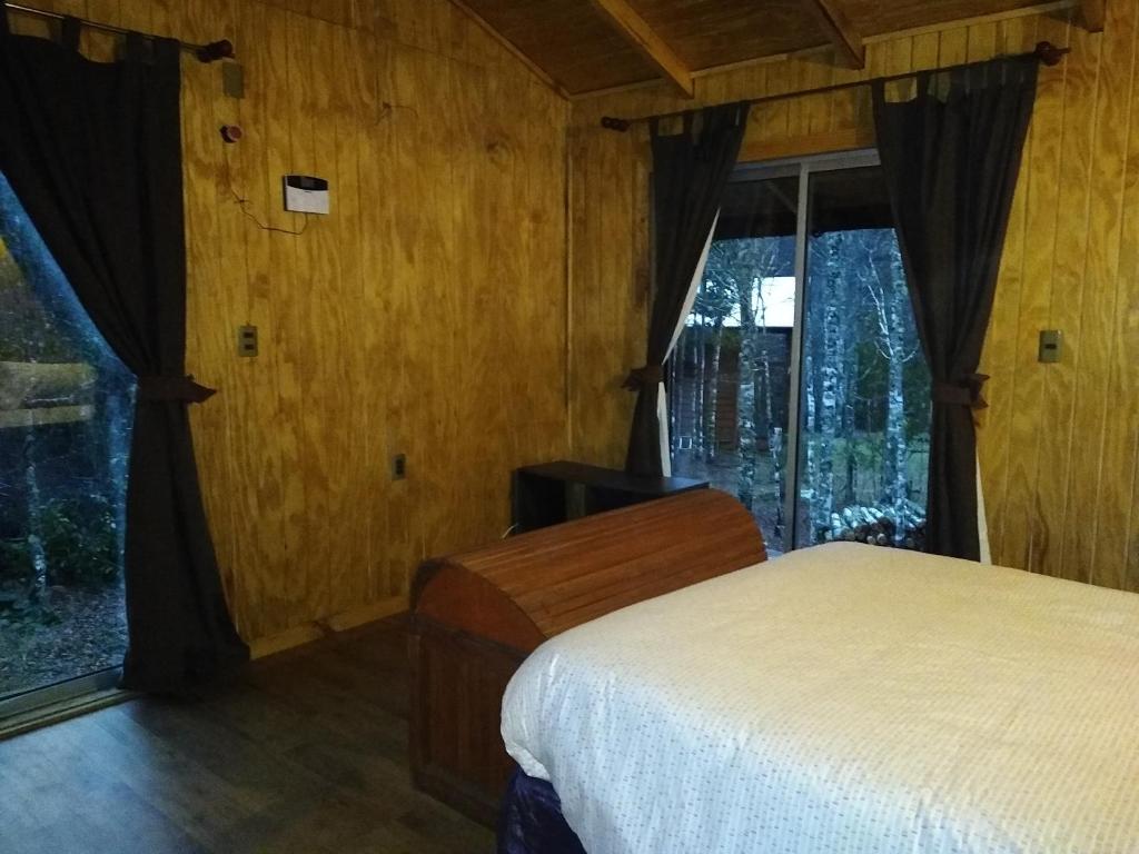 比亚里卡Cabaña entre Arboles的一间卧室设有一张床和一个窗口