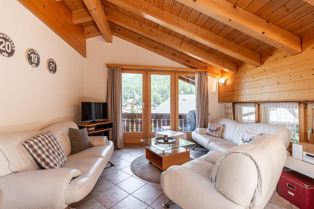 采尔马特Dachwohnung Balma-great overview of Zermatt的客厅配有两张沙发和一台电视机