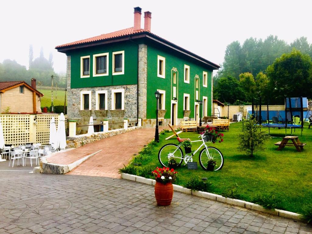 BolguesVilla Palatina的一座绿色房子,前面有一辆自行车停放