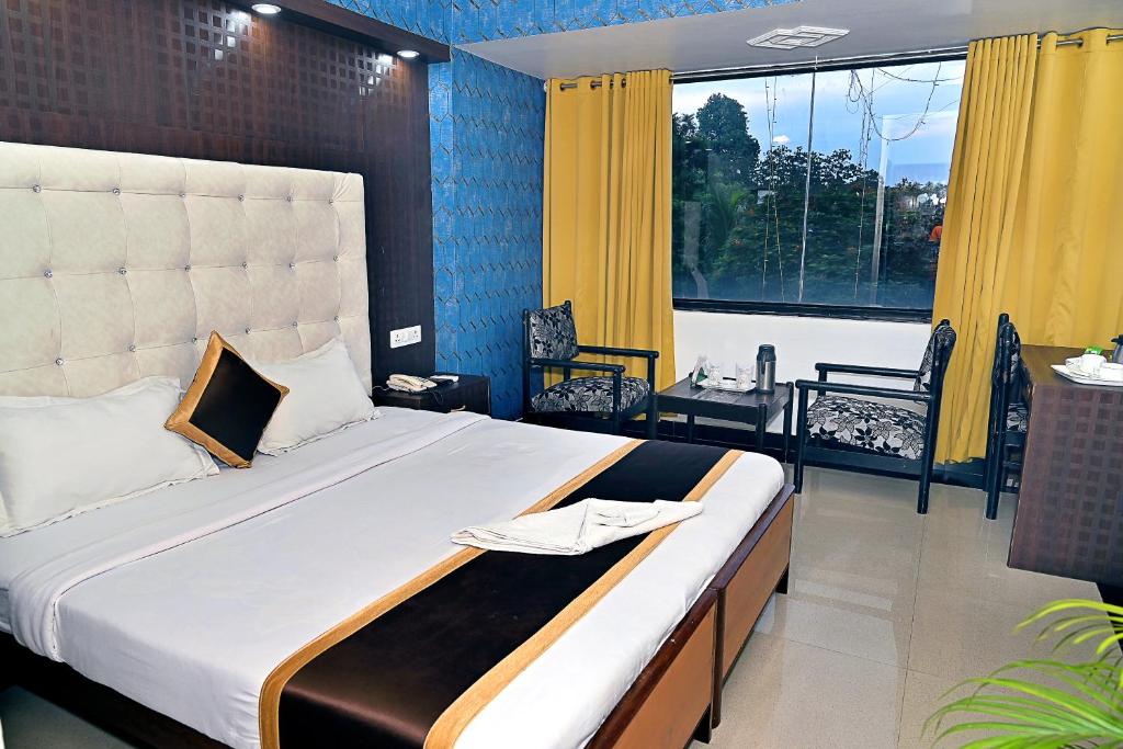 帕格尔布尔Hotel Rajhans International的一间卧室设有一张大床和一个大窗户