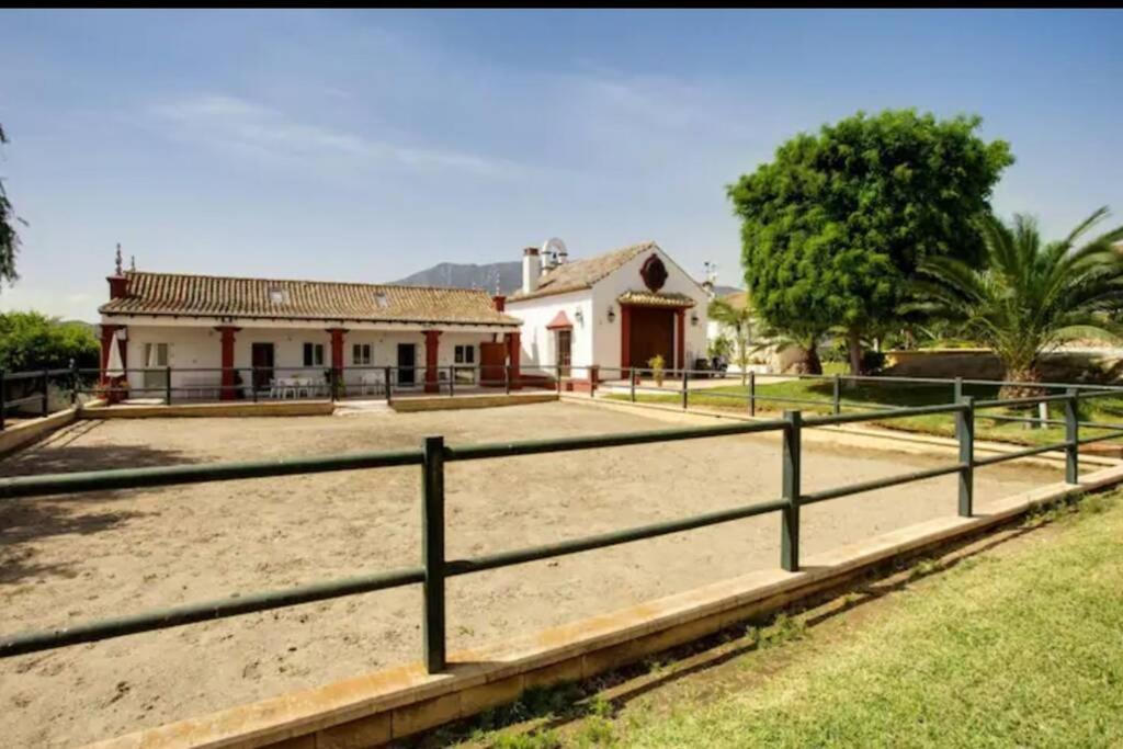 米哈斯科斯塔Finca El Altabacar - Casa Rural - Playa的田野前有围栏的房子