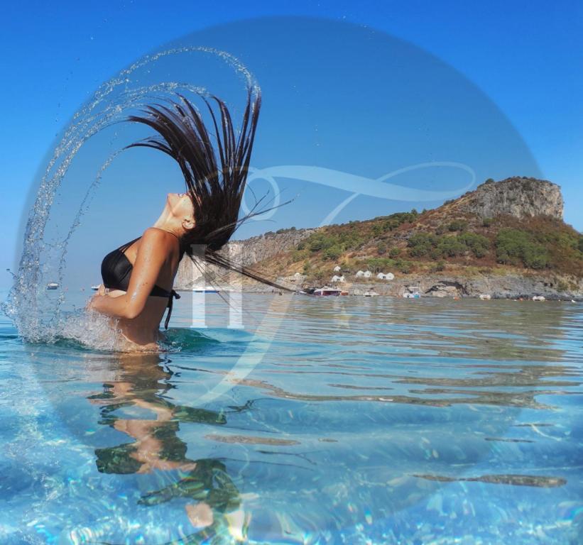 普拉亚·阿马勒Hotel TEA - Praia a Mare的水中一个女人,溅着水花