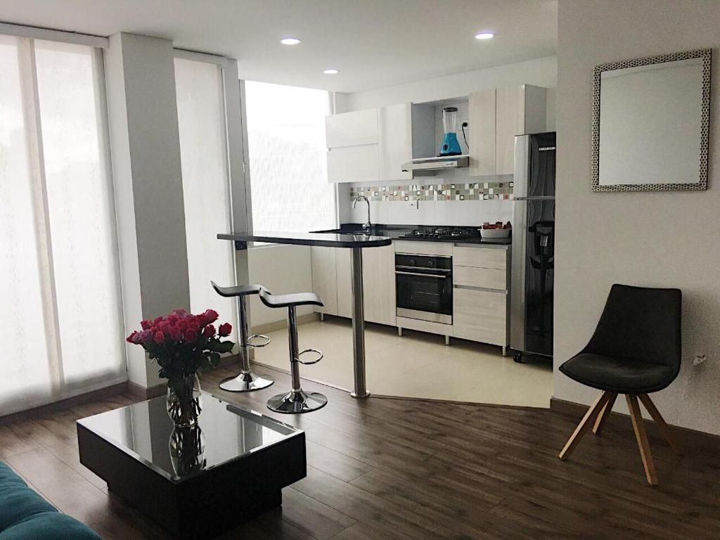 奇亚Espectacular apartamento con estacionamiento gratuito Chía N 2的客厅设有带桌椅的厨房