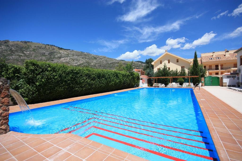 阿罗约弗里奥Apartamentos Rurales Campillo的度假村内的一个蓝色海水游泳池