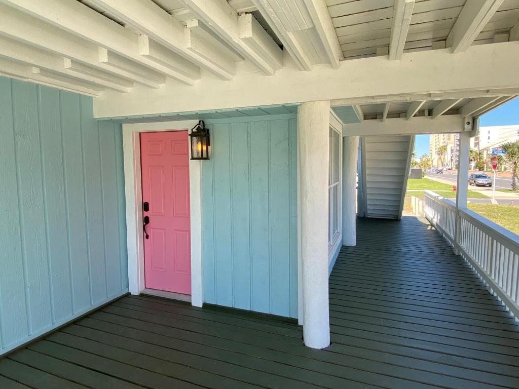 南帕诸岛South Padre Island Beach House Retreat Downstairs的色彩缤纷的前廊,设有粉红色的门