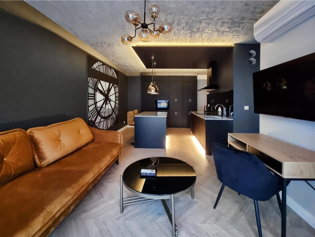什切青Silesia Aparthotel的客厅配有沙发和桌子