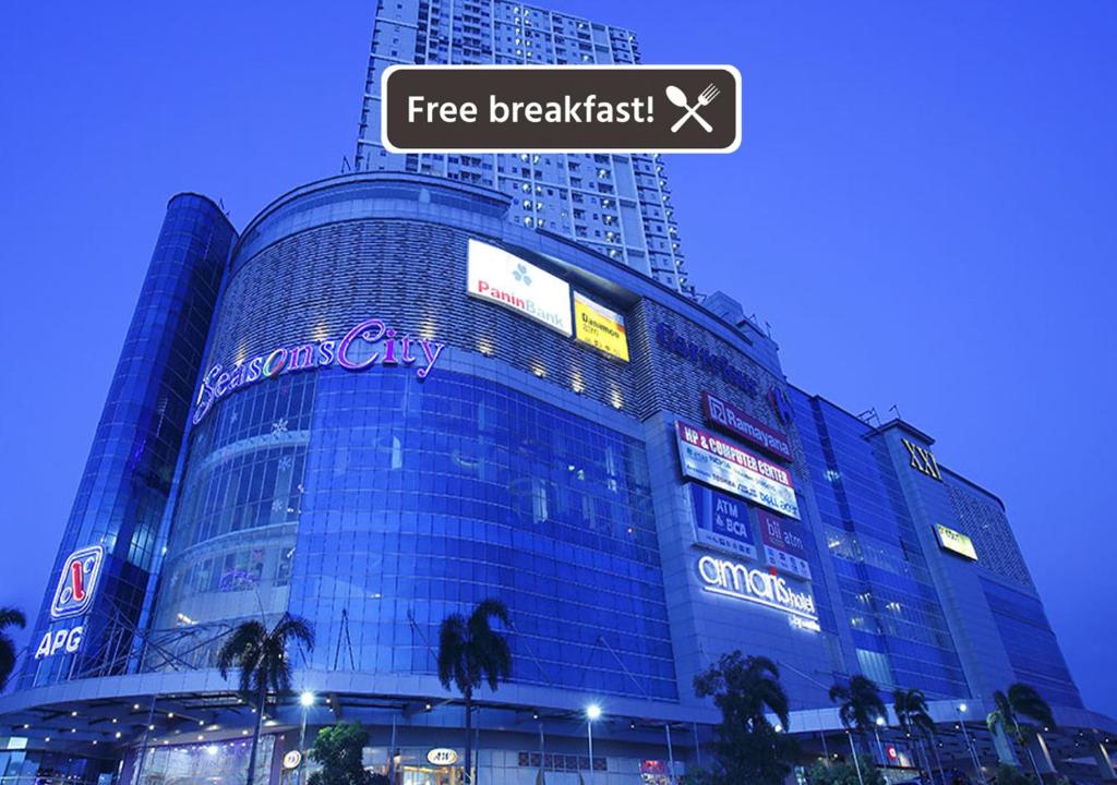 雅加达阿玛丽丝季节城酒店的一座大建筑,上面标有阅读免费早餐的标志