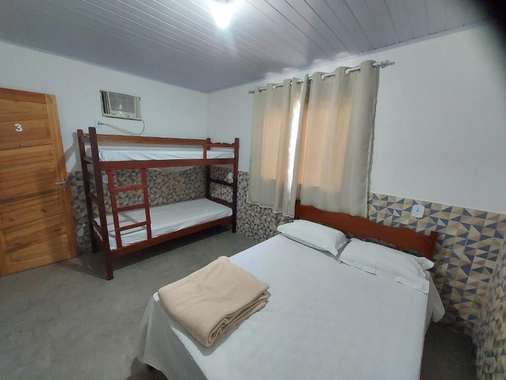 曼加拉蒂巴Pousada do Leô的一间卧室设有两张双层床和梯子