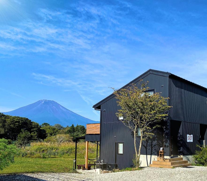 山中湖村SILVER SPRAY MtFuji view Yamanakako的一座黑色的建筑,背景是一座山