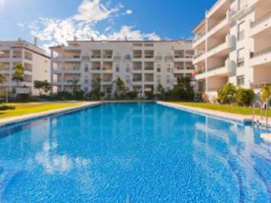 米哈斯科斯塔Apartment Miraflores的大楼前的大型蓝色游泳池