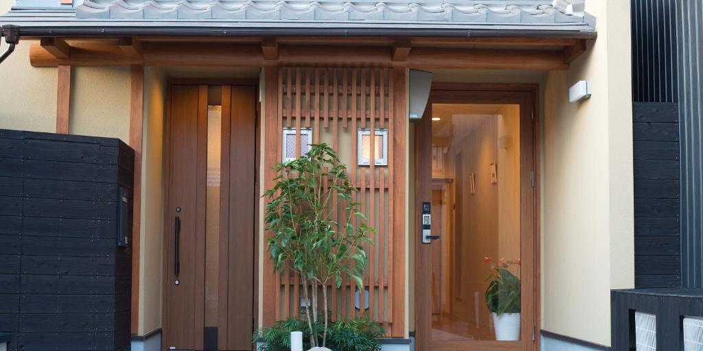 京都Kyo-Anthu Inn的两扇门的房子,前面有植物