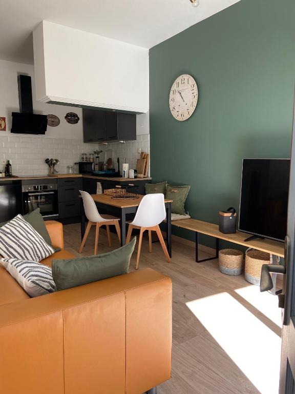 塞特港Appartement cosy plein centre de Sète的客厅配有沙发和墙上的时钟