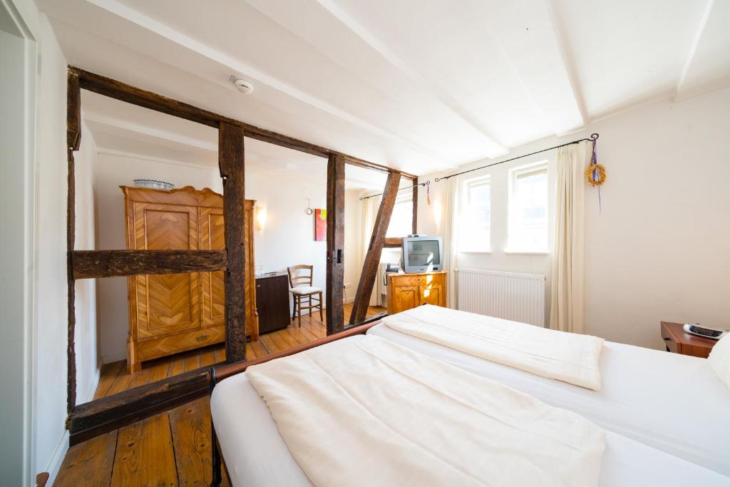 策尔廷根-拉蒂希Gästehaus Ratsschänke的卧室配有白色的床和木门