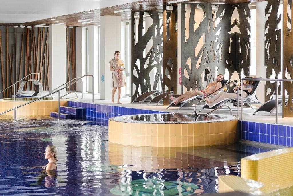 派尔努爱沙尼亚度假酒店及Spa的游泳池与水中的人的 ⁇ 染