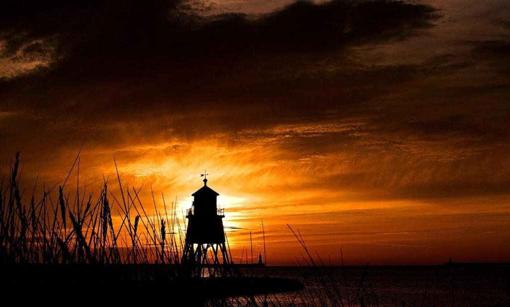南希尔兹Cosy Haven的灯塔的轮廓,背景是日落