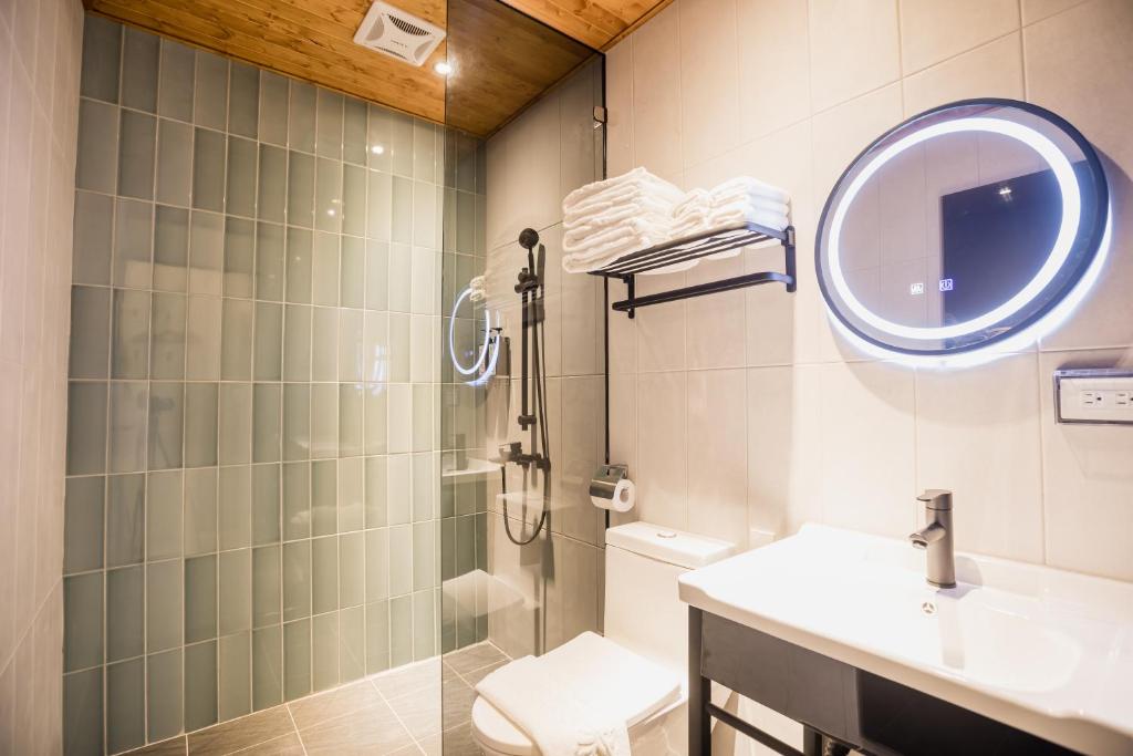 台东旅人驿站日暮微旅的带淋浴、盥洗盆和镜子的浴室