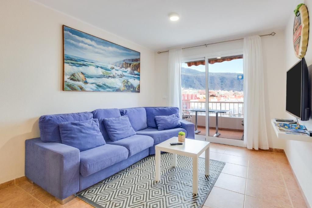 坎德拉里亚Apartamento Deluxe的客厅设有蓝色沙发,配有窗户