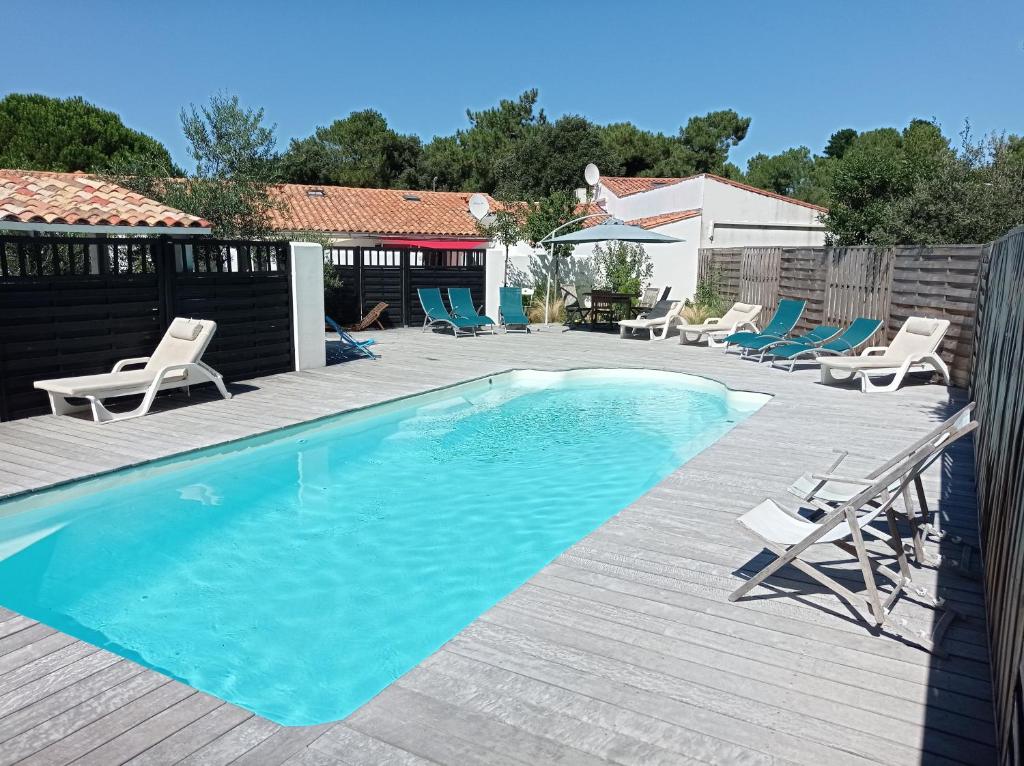 里夫杜海滩Le Clos des Pins的一个带躺椅的游泳池和一个游泳池