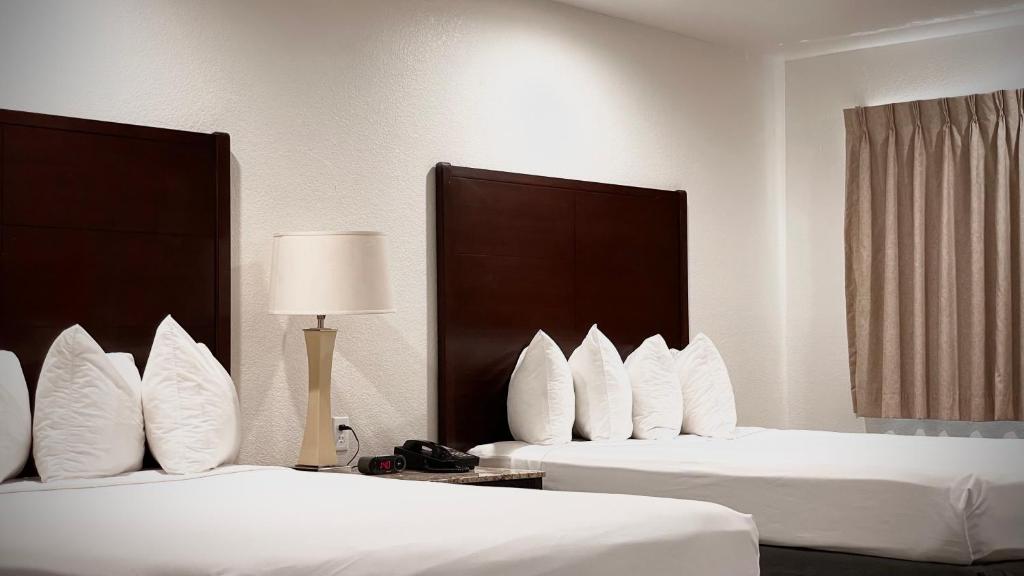 马里波萨The Yosemite Inn的酒店的客房内设有两张带白色枕头的床。
