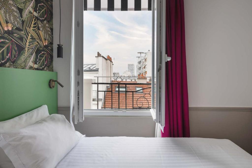 巴黎Hôtel 31 - Paris Tour Eiffel的一间卧室设有一张床和一个美景窗户。