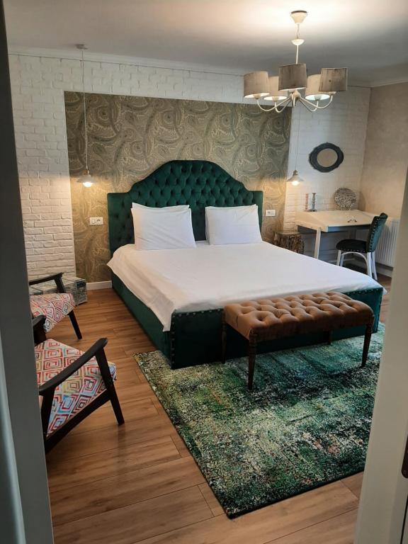 布泽乌Restauro Apartament的一间卧室配有一张大床和绿色床头板