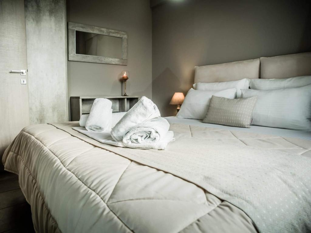 阿利韦里翁Villa Marelia apartments的卧室配有带毛巾的大型白色床