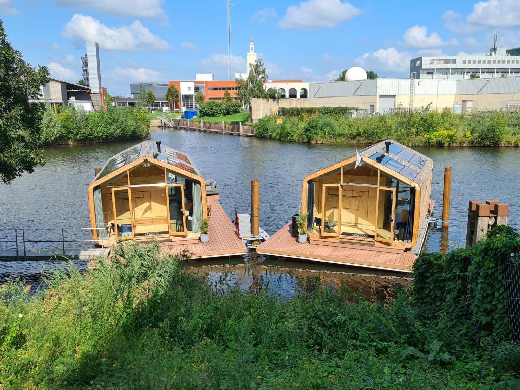OrthenWikkelboats @ Tramkade Den Bosch的两艘小船停靠在河里