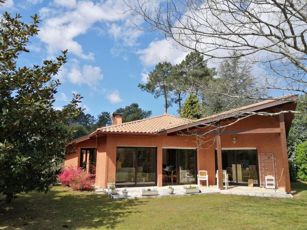 利和米克斯Landes OCEANES - Chambres privées dans villa avec jardin的一座带大窗户和屋顶的房子
