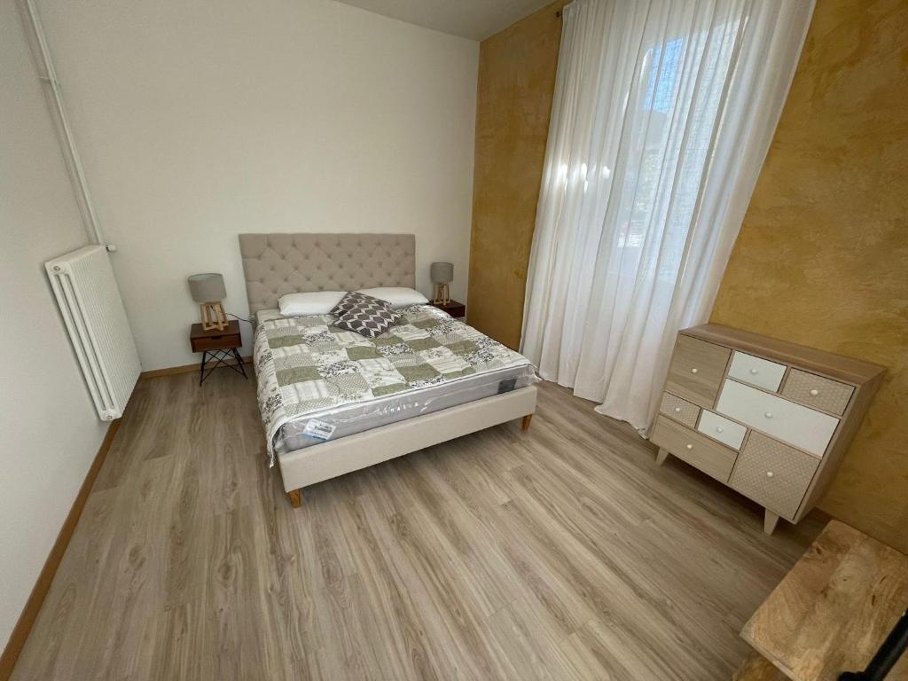 基亚索Smart Living Swiss的一间卧室配有一张床、一个梳妆台和一扇窗户。