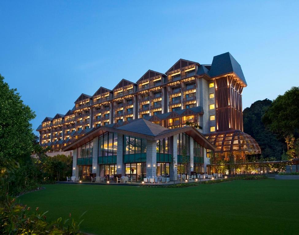 新加坡Resorts World Sentosa - Equarius Hotel的前面有绿色草坪的大建筑