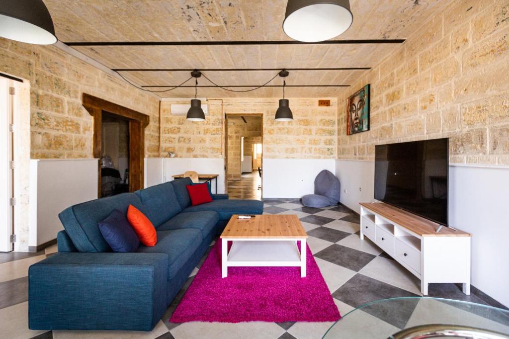 瓦莱塔Valletta Collection - St Pauls Apartment的客厅配有蓝色的沙发和桌子