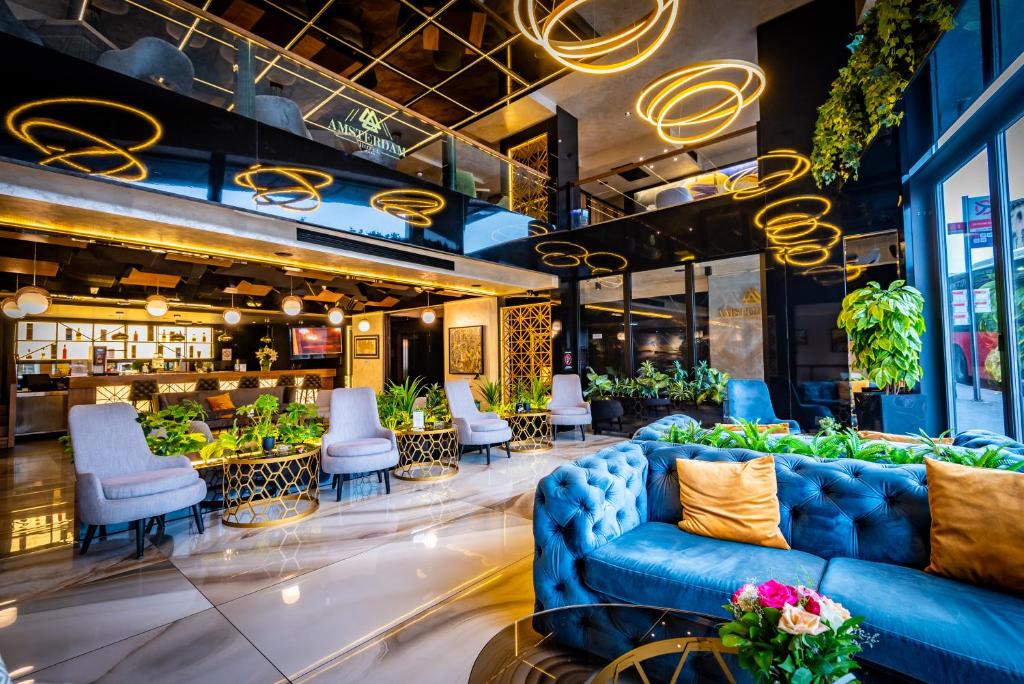 贝尔格莱德Amsterdam Hotel的大堂设有蓝色沙发和椅子的餐厅