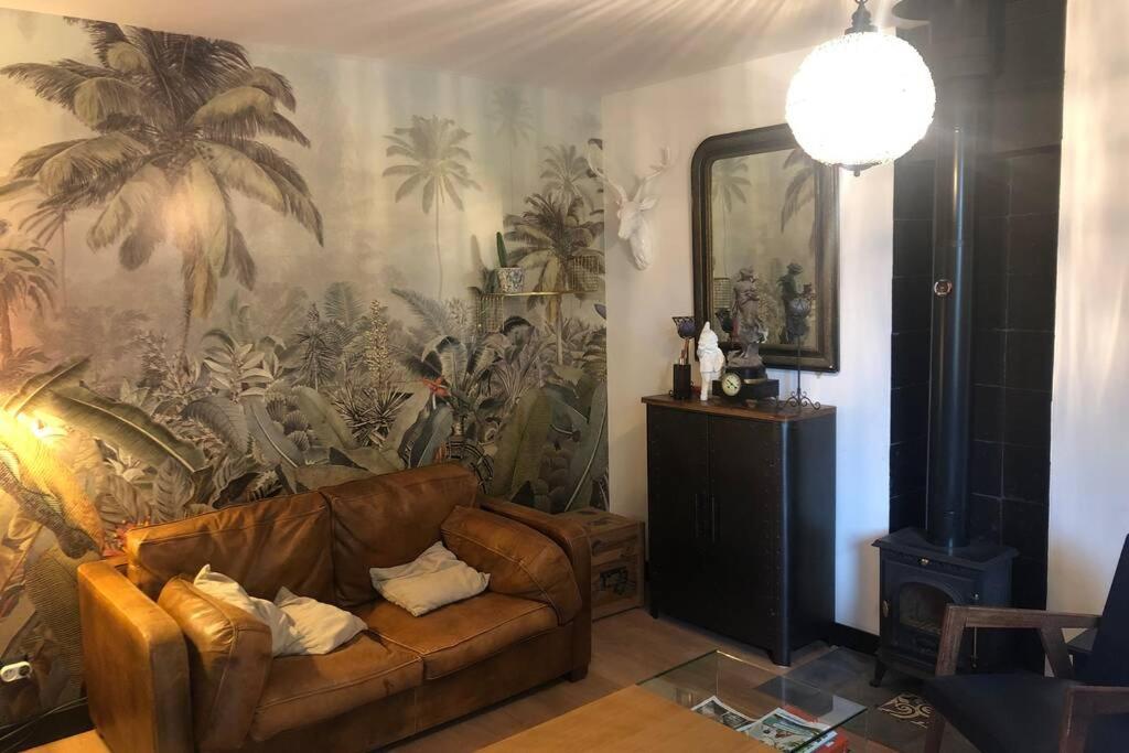 沙尔特尔-德布列塔尼La petite maison dans la jungle的带沙发和大型壁画的客厅