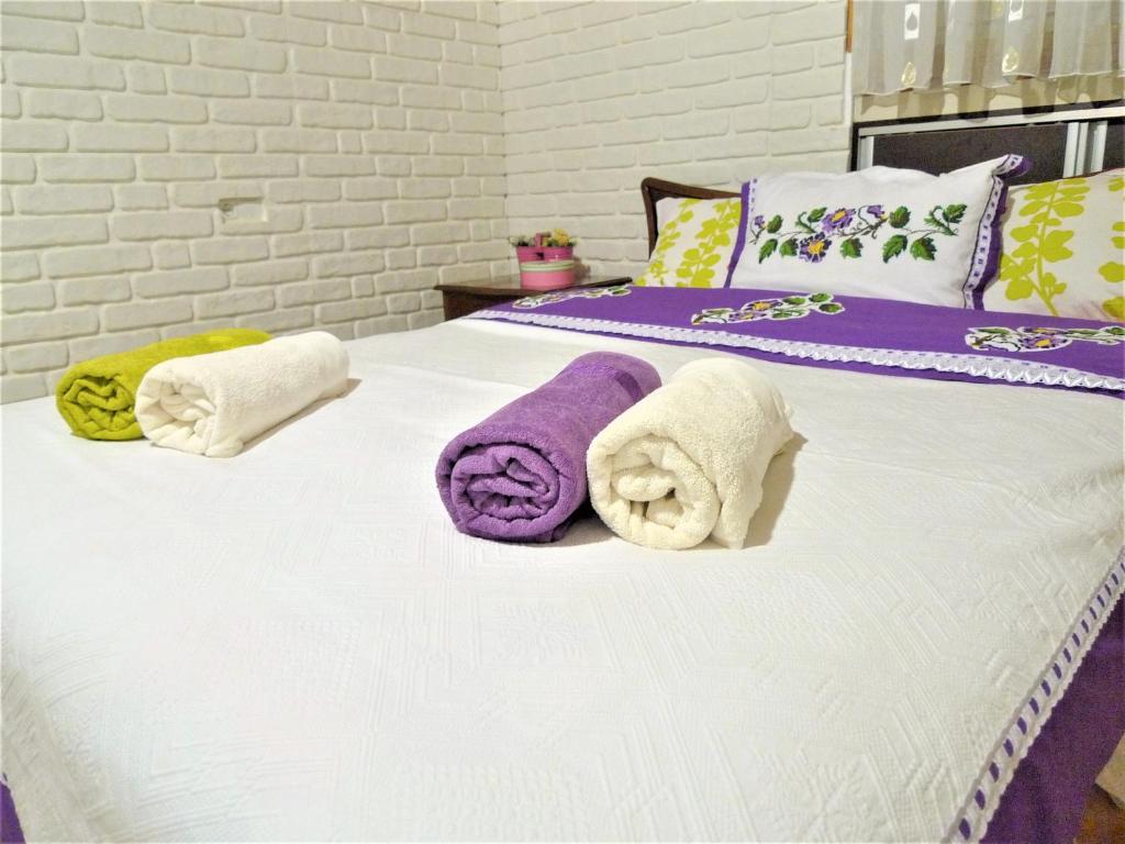 代尼兹利Comfy roof with terrace - 4 TH FLOOR WITHOUT LIFT-1 Air Conditioner的床上铺有紫色和白色毛巾