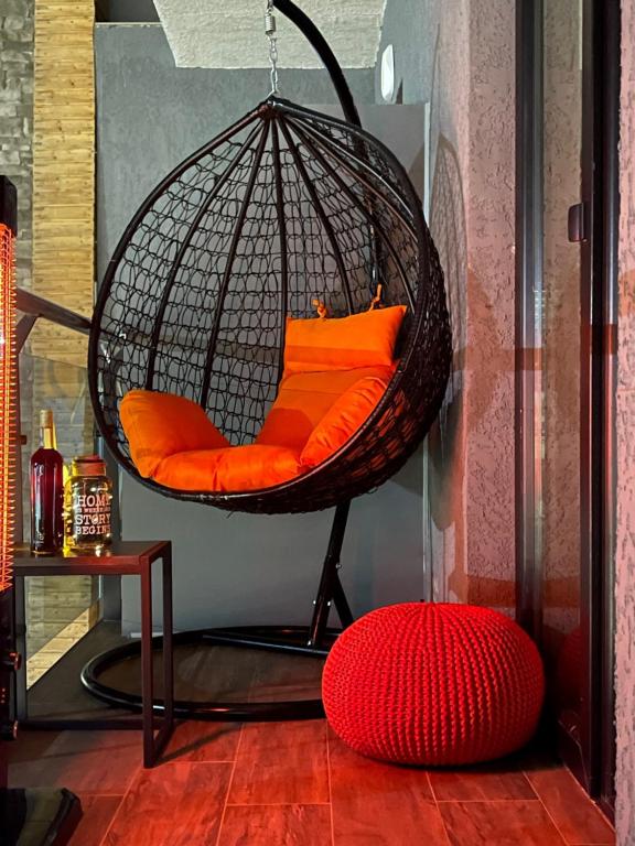 巴库里阿尼Snow Pine Suite - 4 Star Resort的配有橙色枕头和红色靠垫的挂椅
