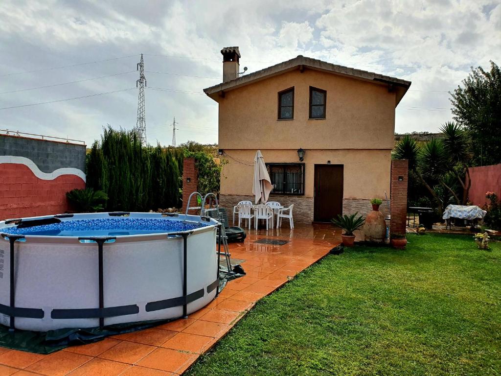 格拉纳达Casa de campo Padul的庭院内带大型热水浴池的房子