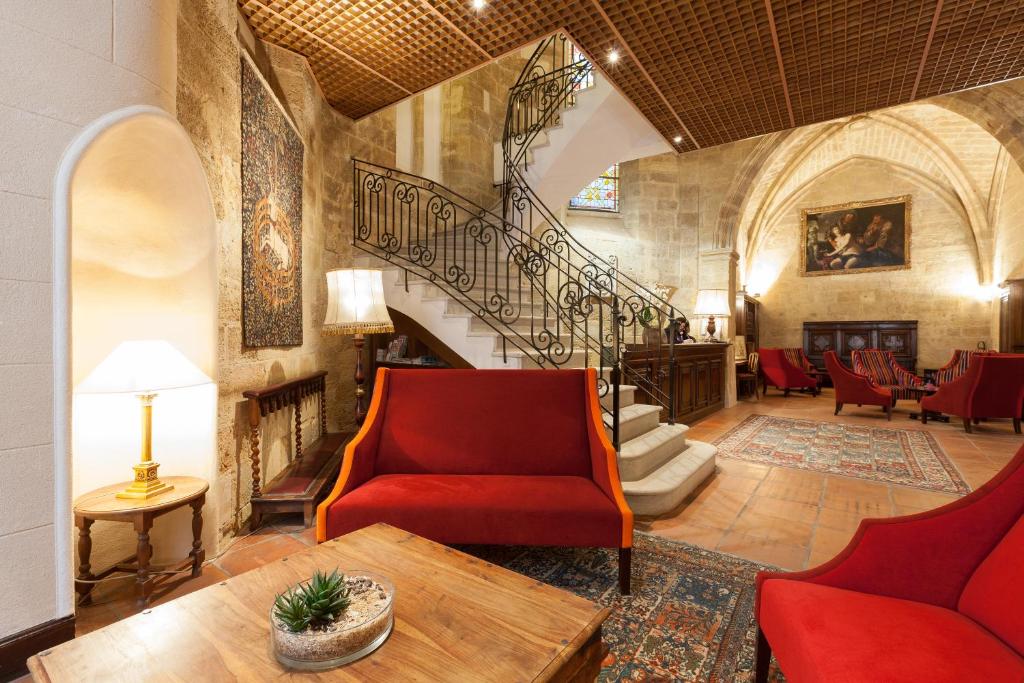 普罗旺斯艾克斯奥古斯丁酒店的一间带楼梯和红色椅子的客厅