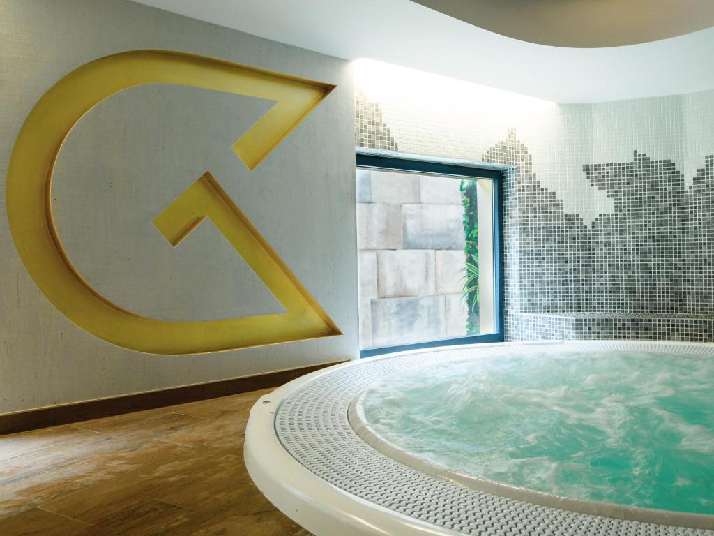 岩尼维利昂内维尔金色郁金香酒店的一个大浴缸,浴室内有大标志