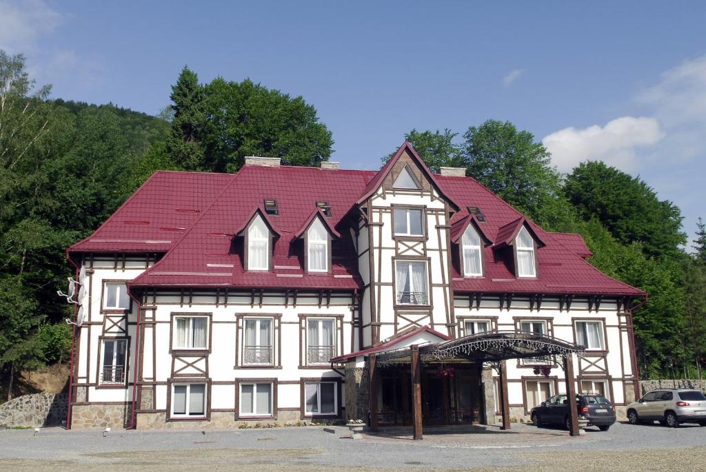 KorostovZolota Forel Hotel的一座白色的大建筑,有红色的屋顶