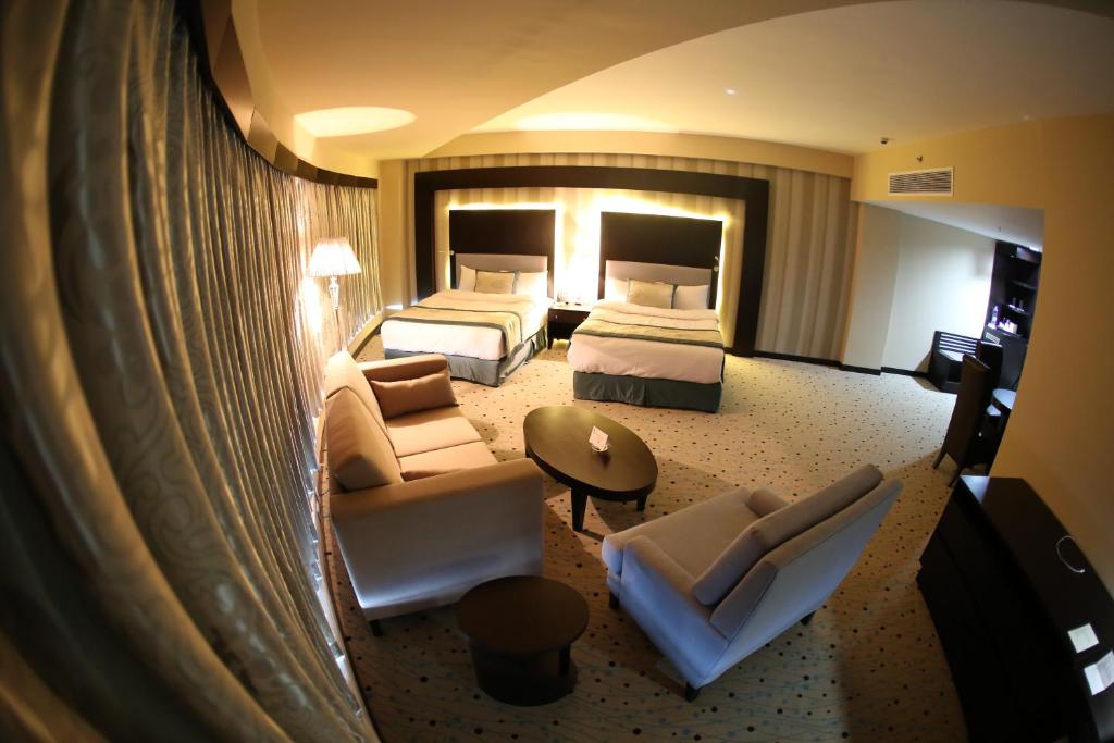 拉马拉巴勒斯坦广场酒店的大型酒店客房 - 带两张床和一张沙发