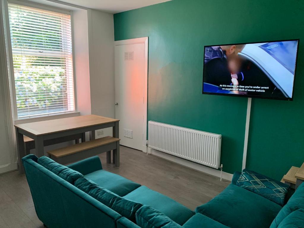 RentonWoodvale Flat, Renton, Loch Lomond的带沙发和平面电视的客厅